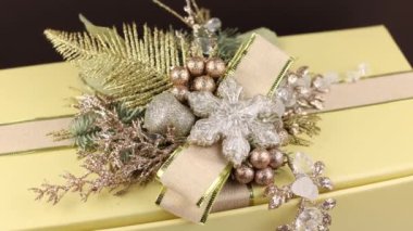 Hediyeli bir kutuda yılbaşı dekoru. Yılbaşı bayramının arka planında koniler ve bir Noel ağacının dalları.