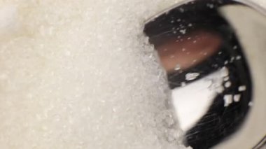 white crystal sugar in a teaspoon close-up macro
