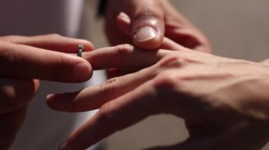 Adam parmağına altın bir yüzük takmış.