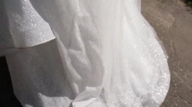 Gelinin güneşin altındaki parlak gelinliği.