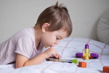 Anaokulu çocuğu evde akıllı telefonla oynuyor.