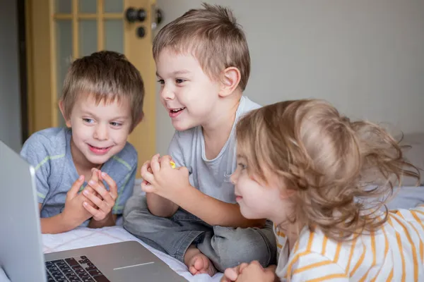 Küçük çocuklar ev yaşamında bilgisayarla görüntülü sohbet ediyorlar.