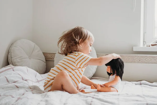 Peuter meisje spelen met haar pop thuis — Stockfoto