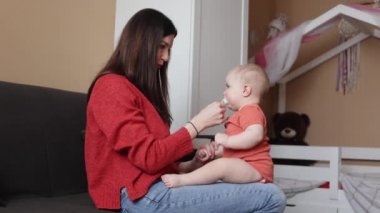 Genç ve neşeli bir kadın yeni doğan koyuyla oynuyor. Anne bebeğiyle vakit geçiriyor. Annelik 
