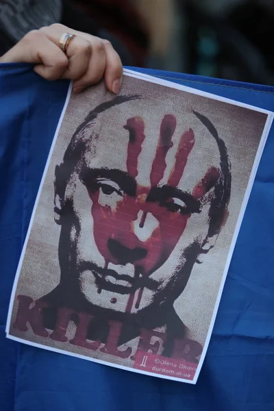 ROME, ITALY, 25.02.2022: Ukrayna topraklarındaki Rusya 'nın savaş operasyonlarına karşı Roma' daki Piazza del Campidoglio 'da toplanan Ukraynalı ve İtalyan protestocular arasında Putin' in kanlı yüzü afişte gösterildi. 