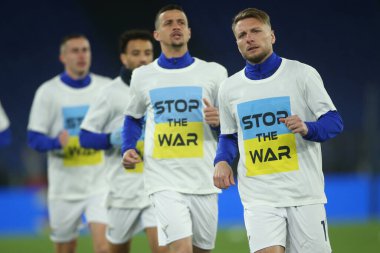 ROME, İtalya - 27.02.2022: Lazio oyuncuları İtalyan Serisi A futbol karşılaşması öncesinde Roma 'daki Olimpiyat stadyumunda SS LAZIO-S NAPOLI arasındaki STOP WAR tişörtüyle ısındılar