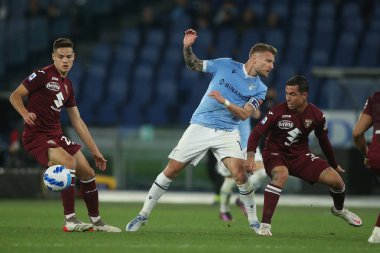 ROME, İtalya - 16.04.2022: CIRO IMMOBILE (LAZIO), IZO ANTONIO (TOR) İtalyan Serisi sırasında SS LAZIO - TORINO FC arasında Roma Olimpiyat Stadyumu 'nda oynanan bir futbol maçı sırasında