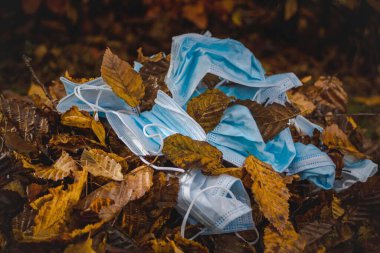 Dried leaves and masks fallen in ground. Bokeh shot