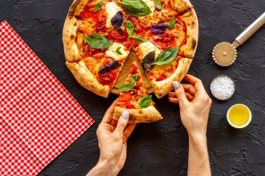 Kadın eli bir dilim pizzayı tutuyor. Genel Görünüm