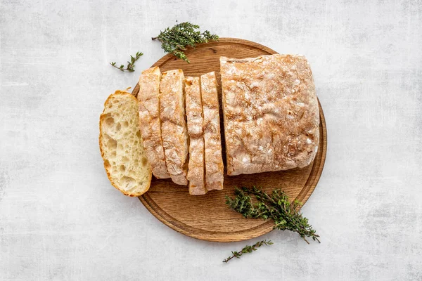 Pokrojone na plasterki ciabatta koraliki na desce tnącej, widok z góry — Zdjęcie stockowe