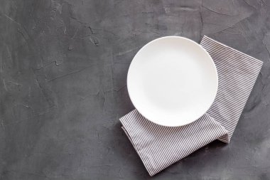 Peçetedeki boş tabağın üst görüntüsü. Akşam yemeği için masayı hazırla.