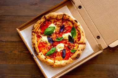 Domates peyniri ve fesleğenle dilimlenmiş İtalyan pizzası.