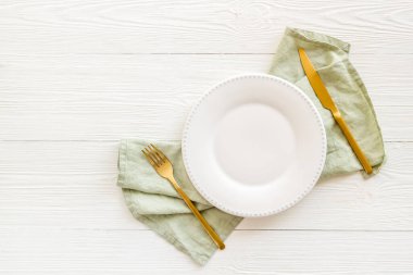 Boş tabak ve çatal bıçak takımı peçeteye. Tablo üst görünümü ayarlıyor