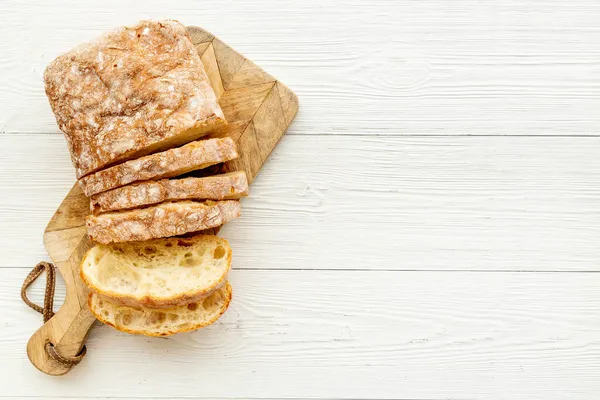 Fatia de pão freashly apoiado na placa de corte, vista superior — Fotografia de Stock
