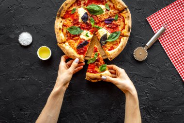 Kadın eli bir dilim pizzayı tutuyor. Genel Görünüm