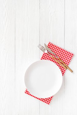 Boş tabak ve çatal bıçak takımı peçeteye. Tablo üst görünümü ayarlıyor