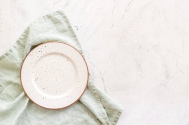 Peçetedeki boş tabağın üst görüntüsü. Akşam yemeği için masayı hazırla.