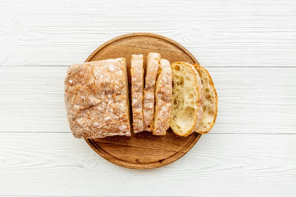 Nakrájená mašle s korálkem ciabatta na řezací desce, pohled shora — Stock fotografie