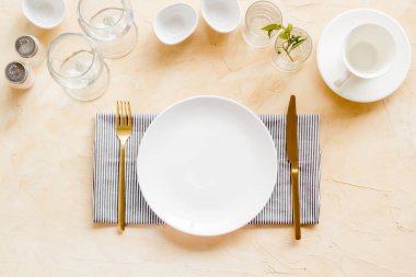 Tabağı boş, tabağı bulaşık takımı ve peçeteli gözlükleri var.