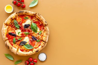 Domates peyniri ve fesleğenle dilimlenmiş İtalyan pizzası.