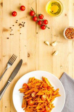 Bir tabak İtalyan makarnası, domates soslu ve otlu.