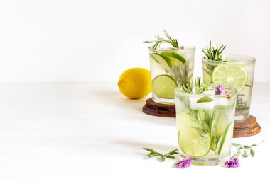 Ev yapımı bitkisel soda, limon dilimleri ve bitkilerle birlikte.