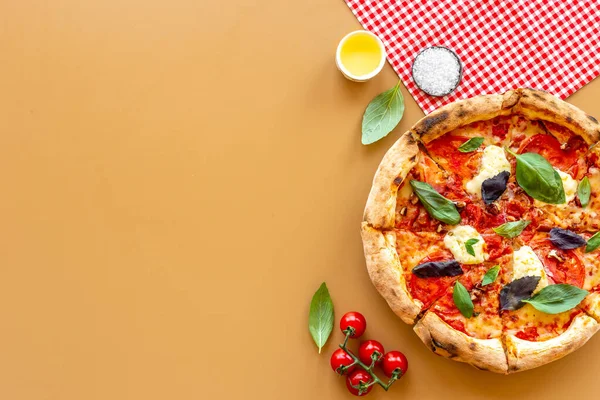 Dipotong menjadi irisan pizza Italia dengan tomat keju dan kemangi Stok Gambar Bebas Royalti