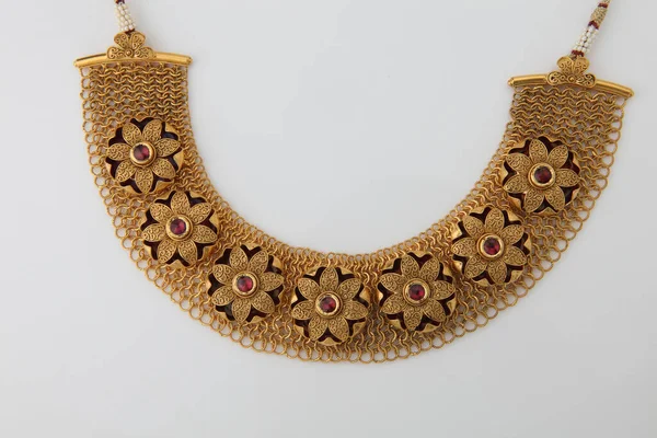 heavy gold necklace on a white base.
