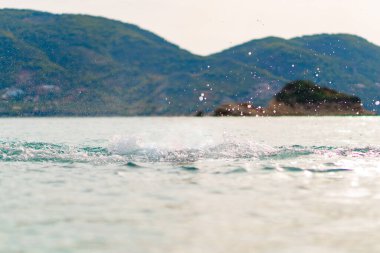 Sea Water Splash With Beautiful Montains Background. High quality photo