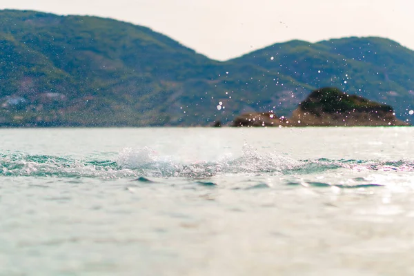 Sea Water Splash With Beautiful Montains Background. High quality photo