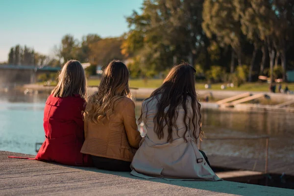 Girls are Talking and Chilling on the River Bank In Beautiful Weather. High quality photo