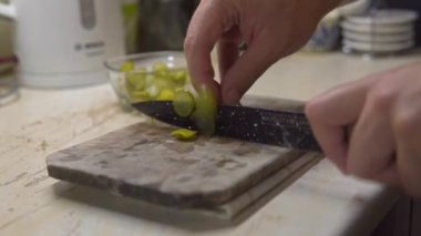 Chefs fast Hand cutting Pickles, at home kitchen, with black knife. High quality 4k footage