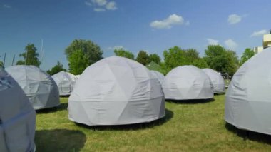 Premium Eden Igloo tents at the Festival Camping, Summer Light, trees in a background. High quality 4k footage