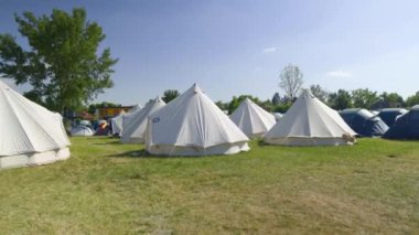 Bell Tents at the Festival Camping, Summer Light, trees in a background. High quality 4k footage