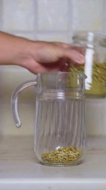 Chamomile Tea Making in a Jug, Scald of chamomile flowers with hot fresh Water In Modern Kitchen. High quality 4k footage