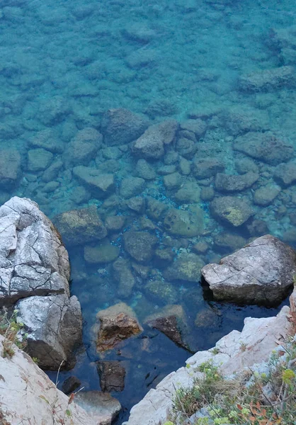 蓝绿色卵石背景上有阳光的海水 高质量的照片 — 图库照片