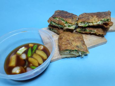 Very delicious martabak telur stuffed inside with sliced spring onions and duck egg in a specially made sauce with a little palm sugar, vinegar and sliced cucumber, chili and shallots