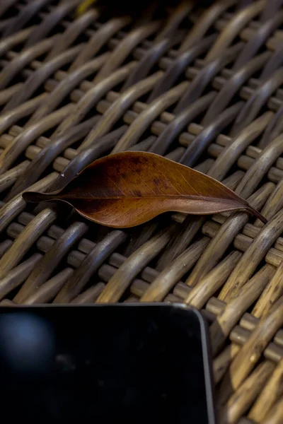 Сухие Листья Текстурированном Столе Рядом Смартфоном — стоковое фото
