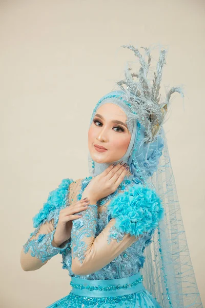 Beauty Fashion asian woman in hijab with Makeup and wearing blue wedding dress.