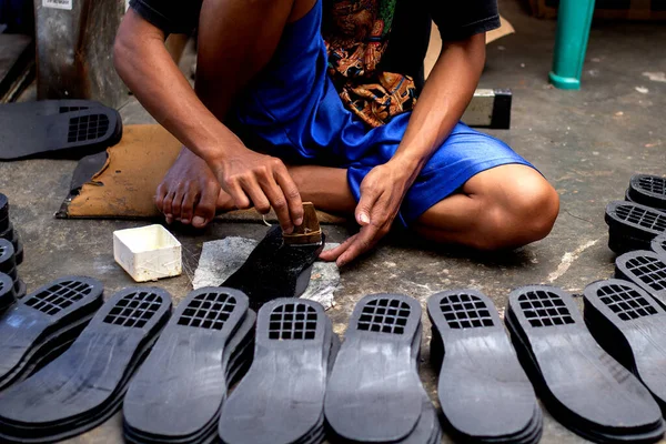 Magetan Leather Craft Workers. Portrait of a leather craftsman making sandals typical of Magetan, East Java - Indonesia.