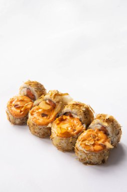 sushi rolls sprinkled with tuna chips and Philadelphia cheese and salmon and sauce