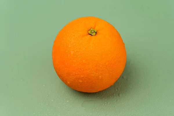 Single Orange Een Groene Achtergrond — Stockfoto