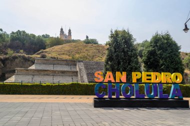 Colorful Sign for San Pedro de Cholula in front of the Giant Pyramid of Cholula and Santuario de la Virgen de los Remedios
