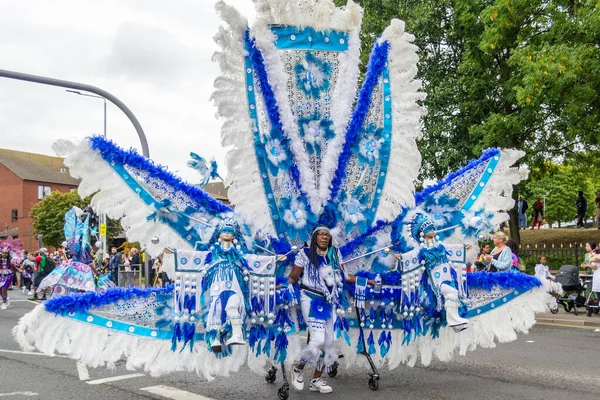 Leeds, Birleşik Krallık - 29 Ağustos 2022: Leeds West Indian Carnival Parade 'de 29 Ağustos 2022' de Leeds, İngiltere 'de dev mavi beyaz kostümlü kadın
