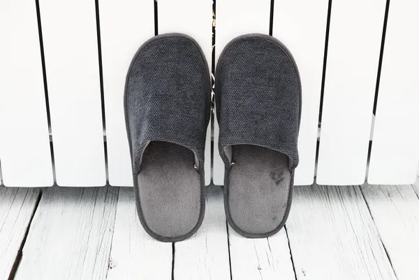 灰色拖鞋正在公寓的白色散热器附近晒干 干净温暖的家用凉鞋或运动鞋 床上用品鞋类 — 图库照片