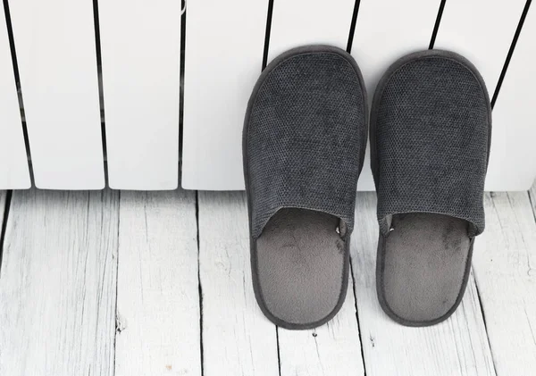 灰色拖鞋正在公寓的白色散热器附近晒干 干净温暖的家用凉鞋或运动鞋 床上用品鞋类 — 图库照片