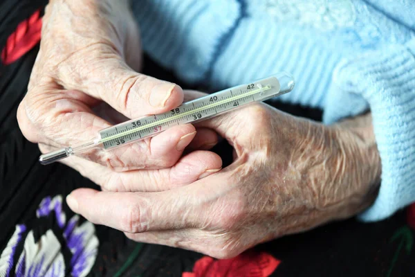 90歳の祖母は水銀温度計を手に持っている 隔離中の高齢者の保護 — ストック写真