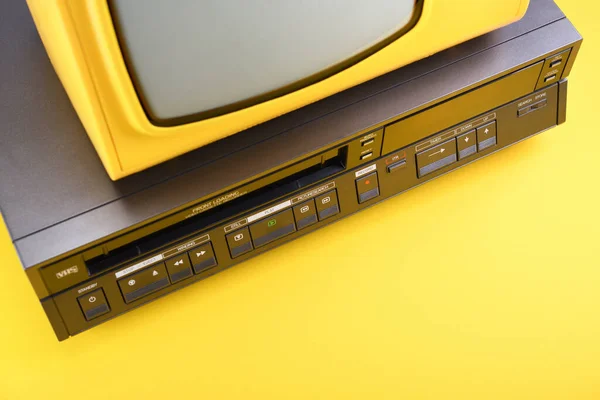 20世纪80年代 90年代 21世纪初带有录像机的老式黄色老式电视机 背景为黄色 — 图库照片