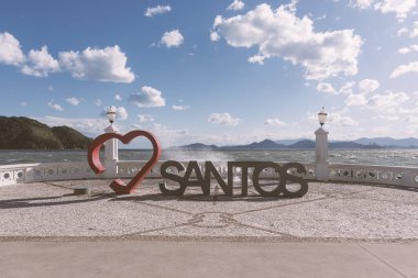 Santos, Brazil - August 10, 2022: I love the city of Santos. Red heart. Sculpture. Tourist attraction to take pictures by the sea, including the city landmark wall.