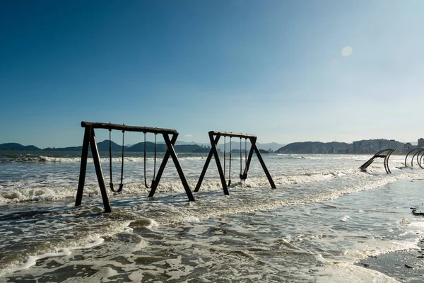 City of Santos, Brazil. High tide invades the sand strip and the children's playground.